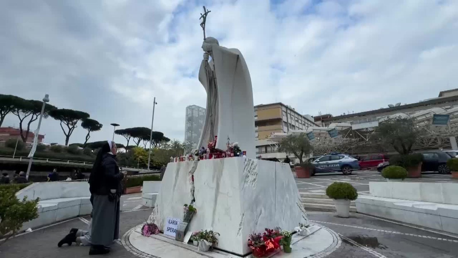Los fieles improvisan un altar por el papa con flores y velas a las puertas del hospital